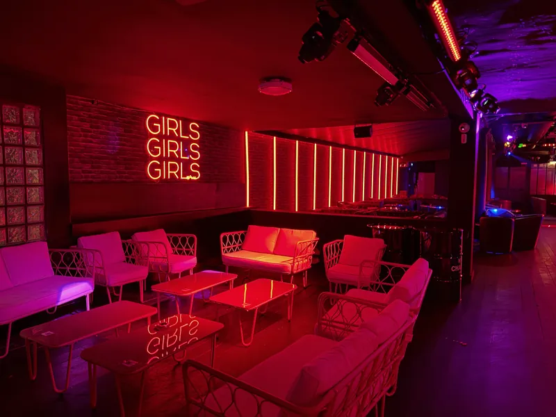 Espace lounge du Maya Klub avec néon et fauteuils blancs